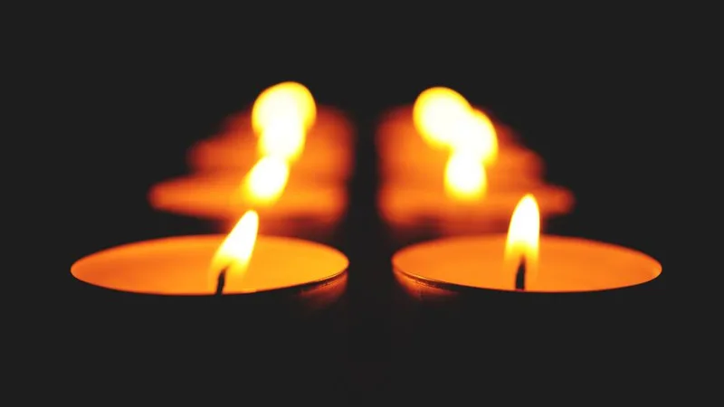 Two lit candles in the dark