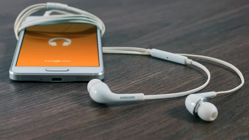A smartphone with earphones on a wooden table