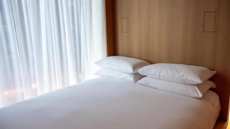 A made hotel bed with white linens