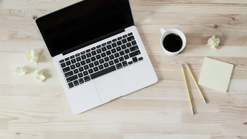 Laptop, coffee and notes on a wooden desk