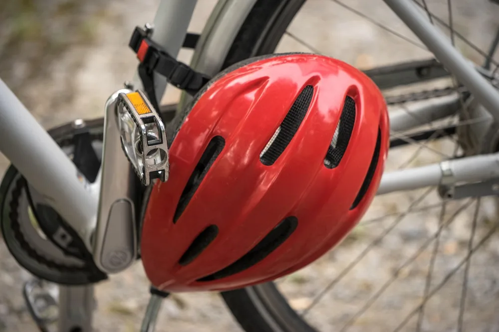 Red bicycle helmet hanging on a bike